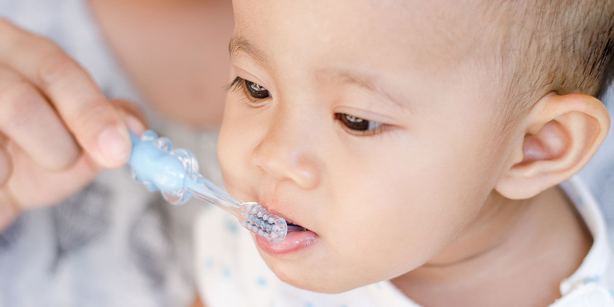 Parent brushing infant's teeth